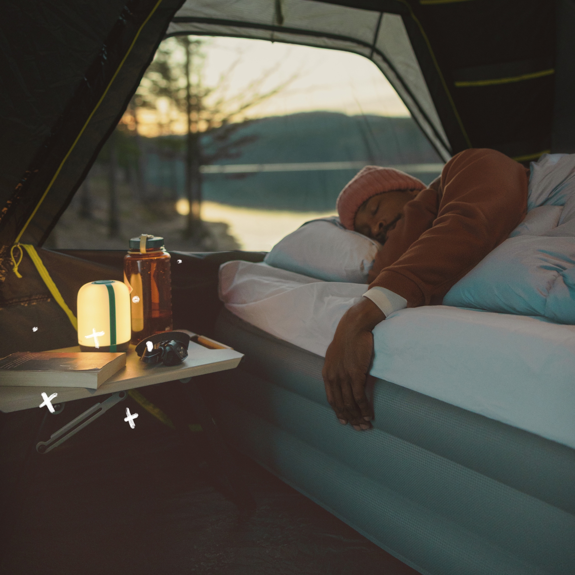 A person sleeps soundly on an air bed in their tent.
