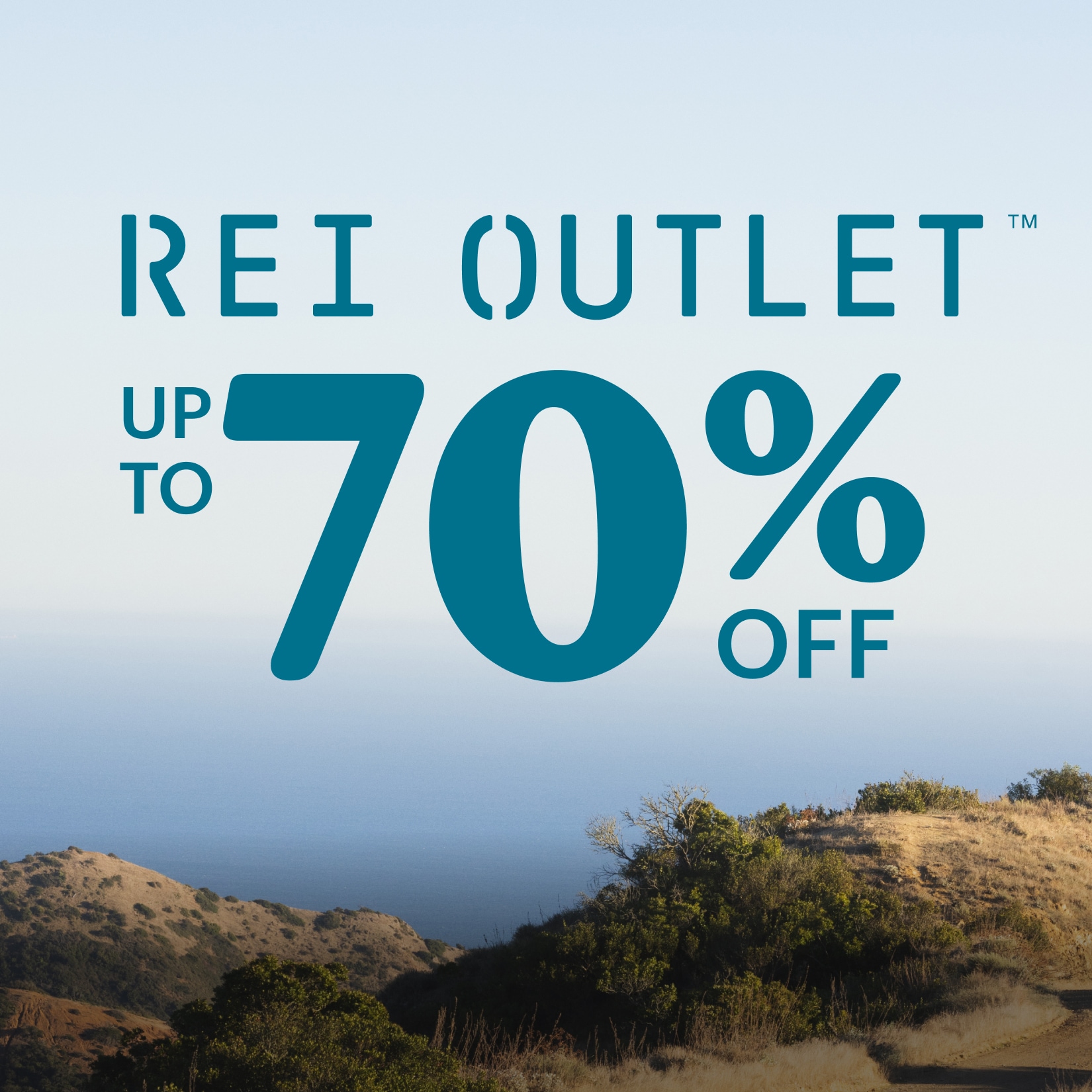 An image overlooking grassy hills. Text reads: ‘Up to 70% off R E I Outlet.’