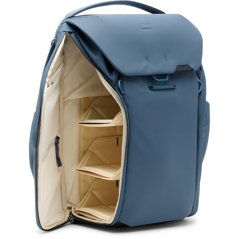 A blue pack with compartments for photo equipment stands up against a white background