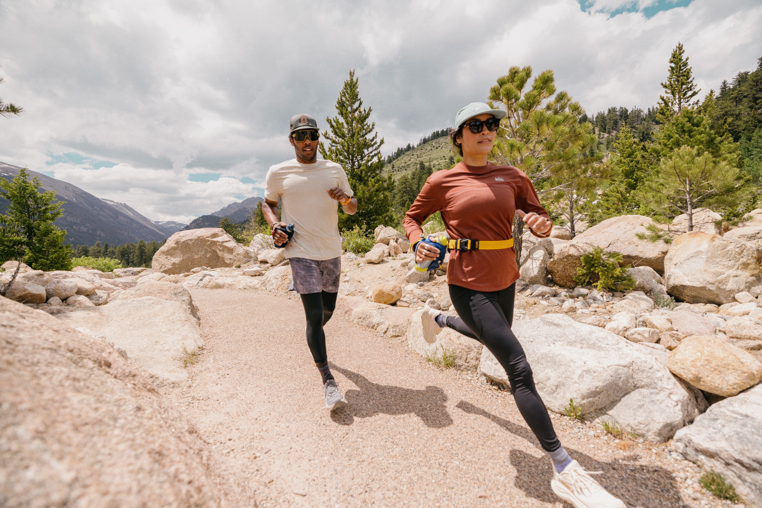 A man and woman running on a trail.