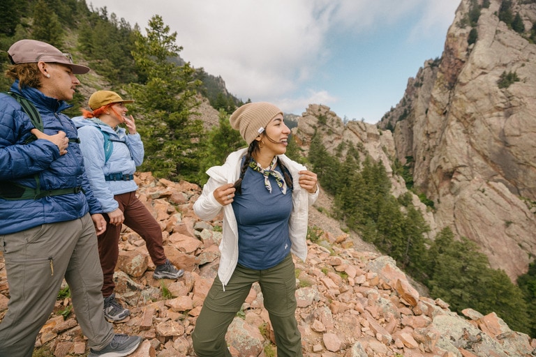 A hiker with two friends wears an insulated jacket over a base layer.