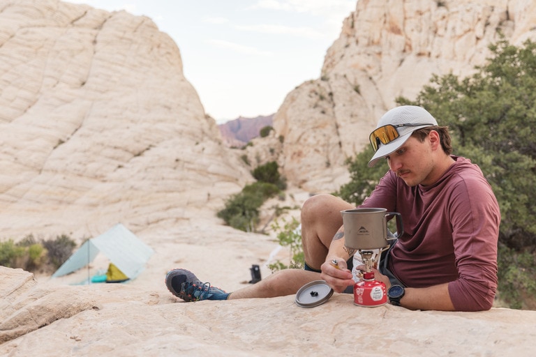A fast packer boils water away from his tarp tent system