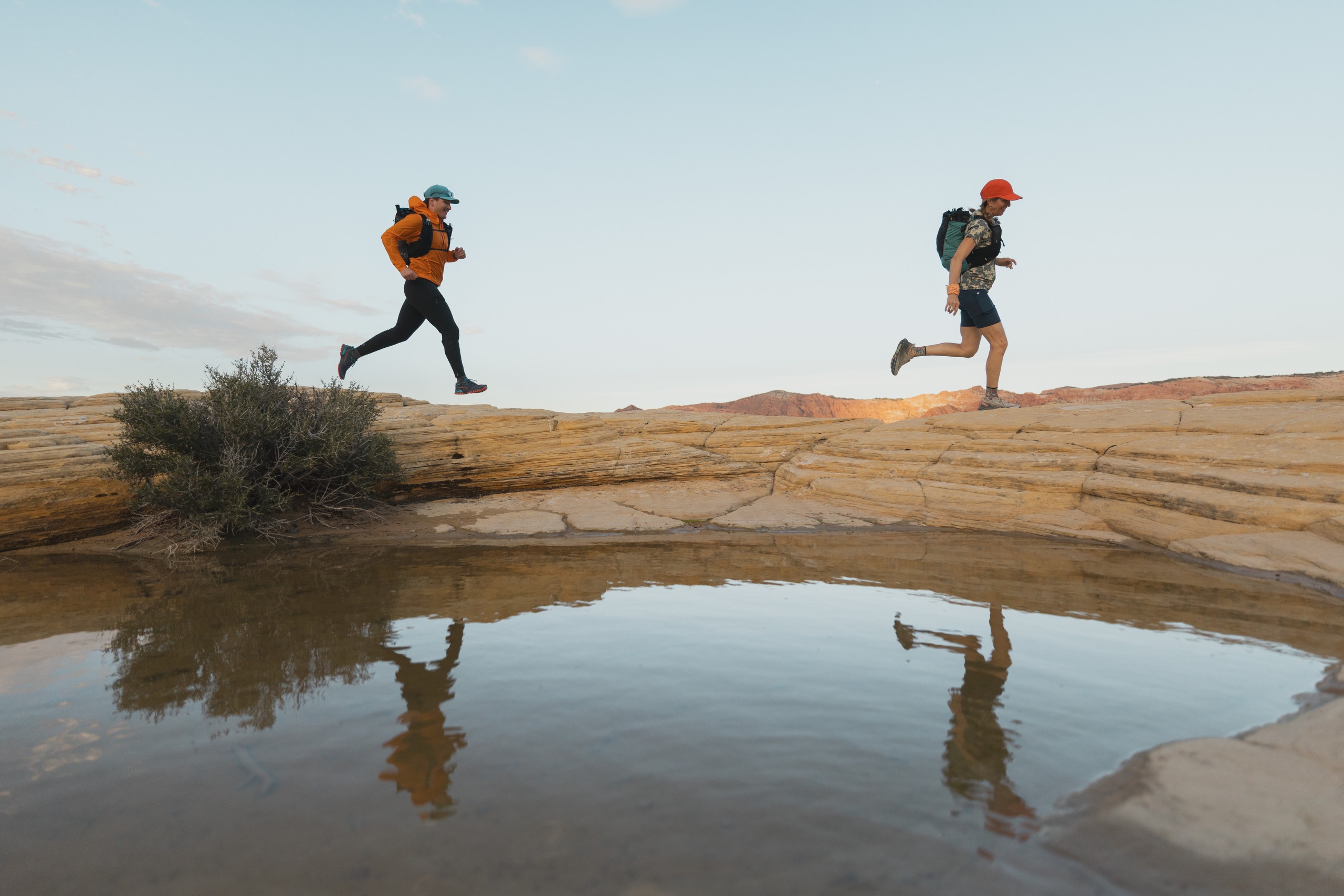 Two fastpackers run/hike across the desert landscape