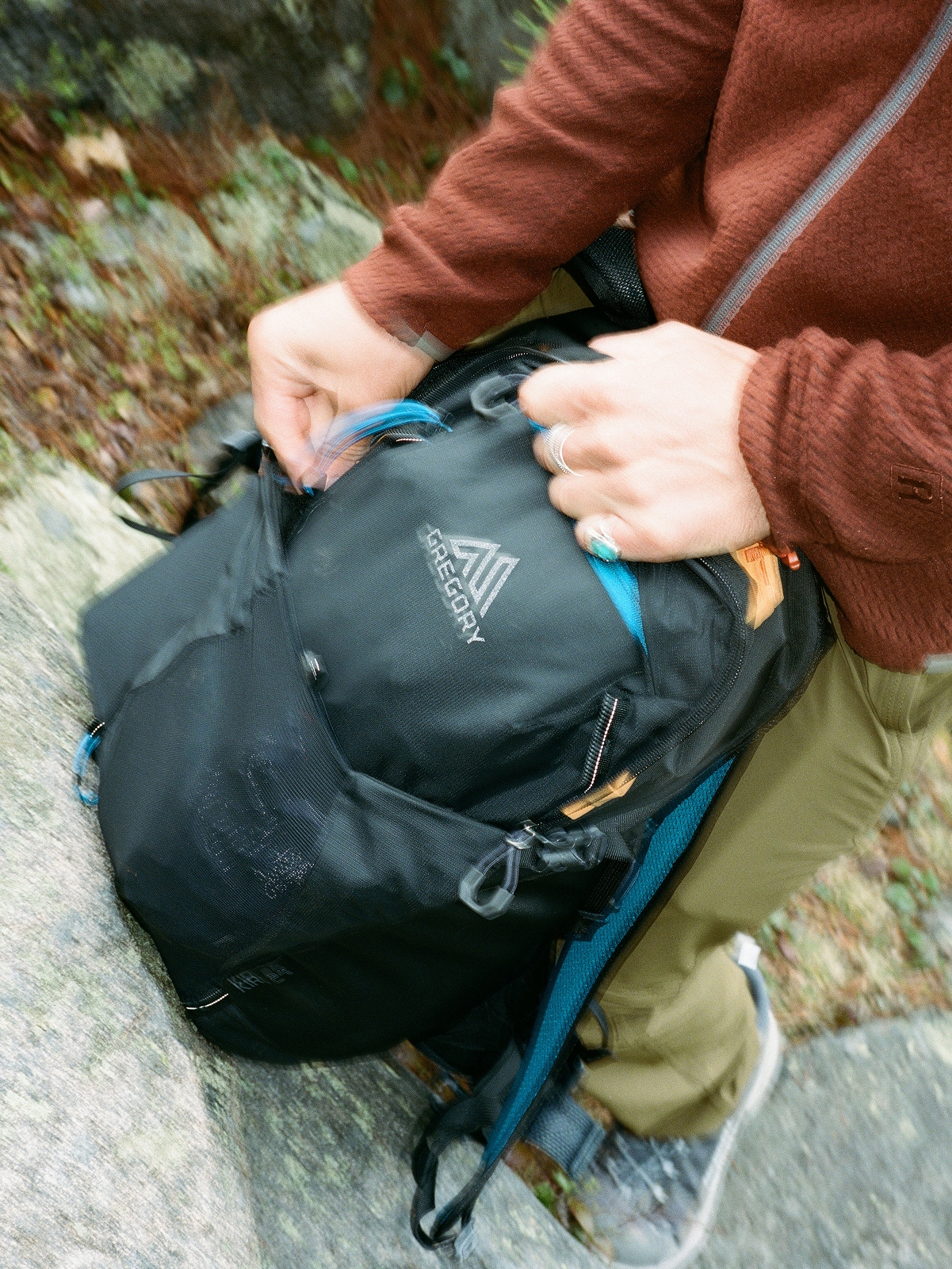 A hiker zips up their Gregory pack.