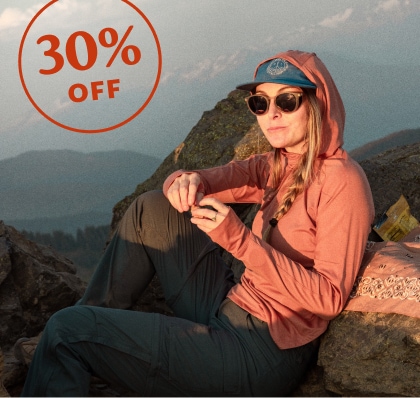 30 percent off. A person takes a break from their hike to sit down while enjoying a snack.