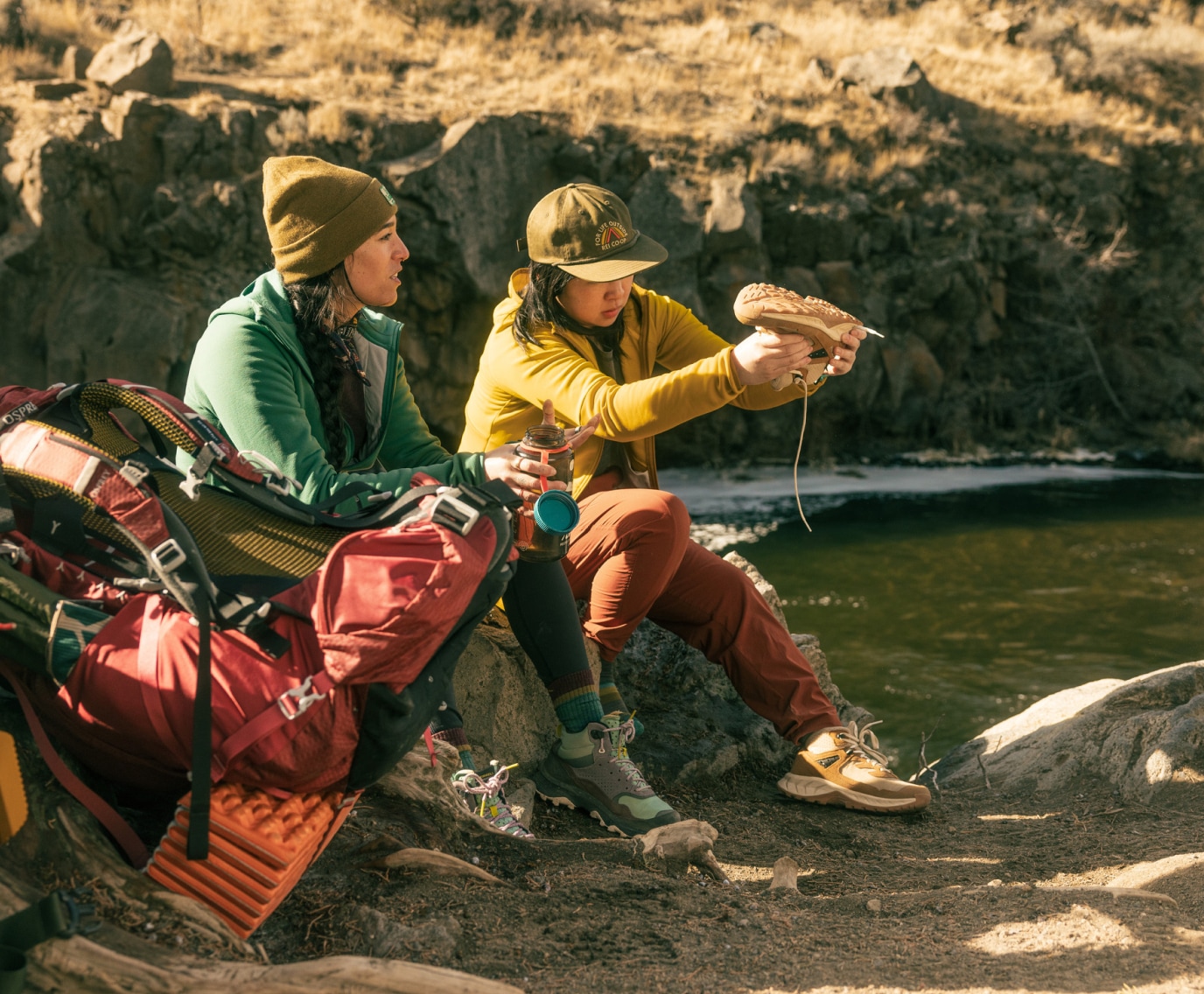 Two people sit down to take a break during a hike.