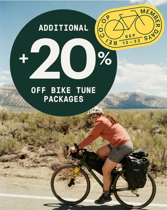 Extra 20% off bike tune packages during Member Days. A person rides their bike on a sunny day.