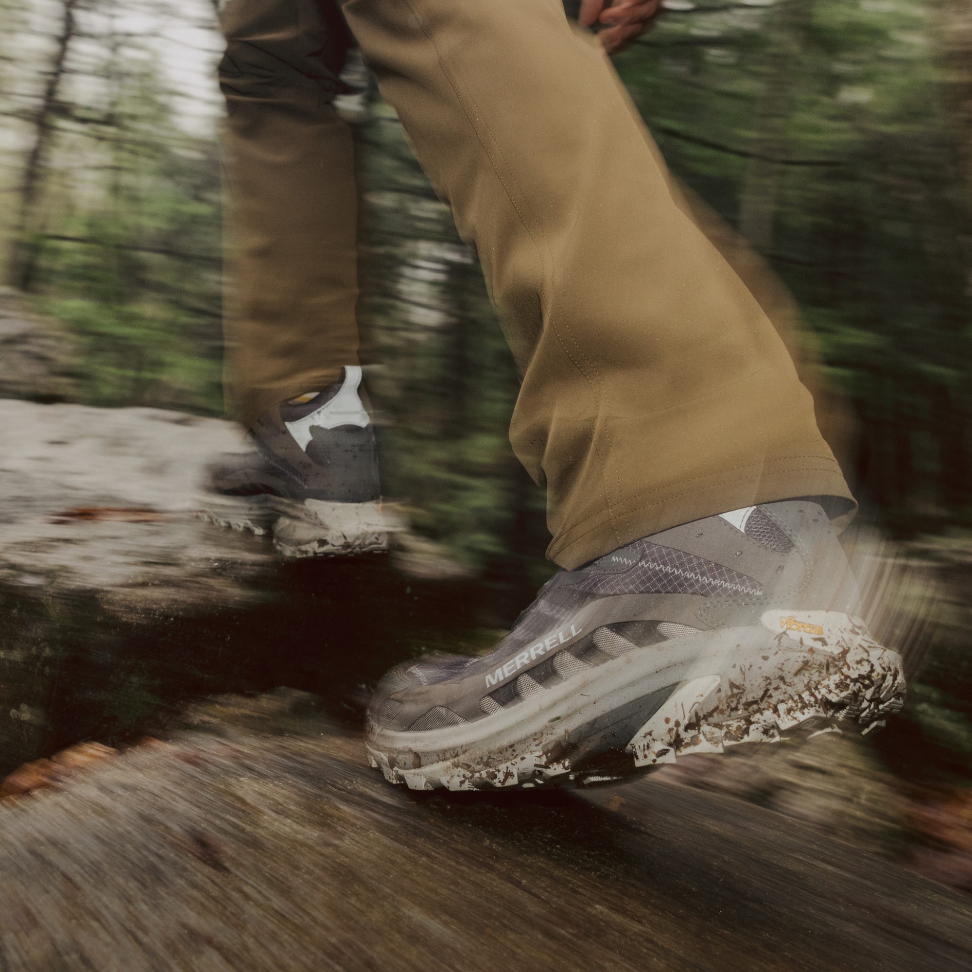 A person treks through a rocky trail in their Merrell hiking shoes.