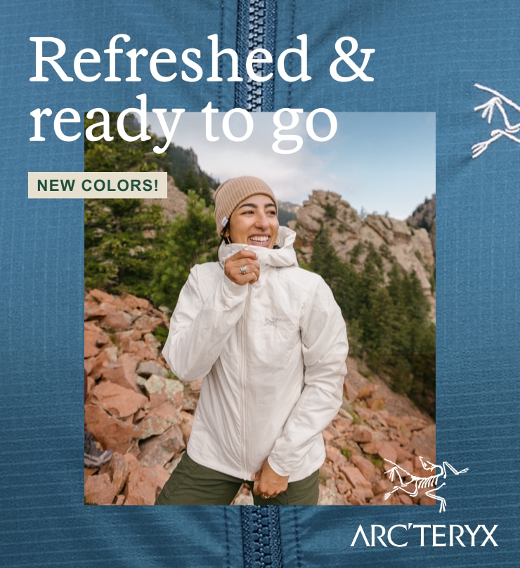 A gleeful hiker clutching the zipper on her Arc'teryx jacket. Headline: Refreshed & ready to go