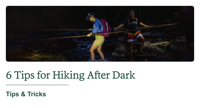 Two pals hiking after nightfall. Headline: 6 Tips for Hiking After Dark. Tips & Tricks