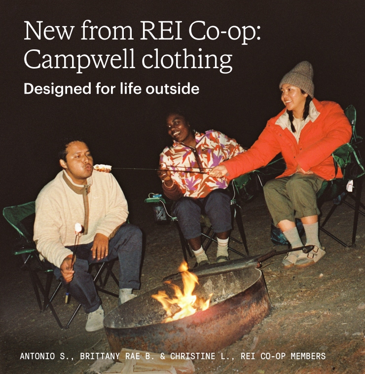 Group of friends roast marshmallows around a campfire. Headline: New from REI Co-op: Campwell clothing. Designed for life outside
