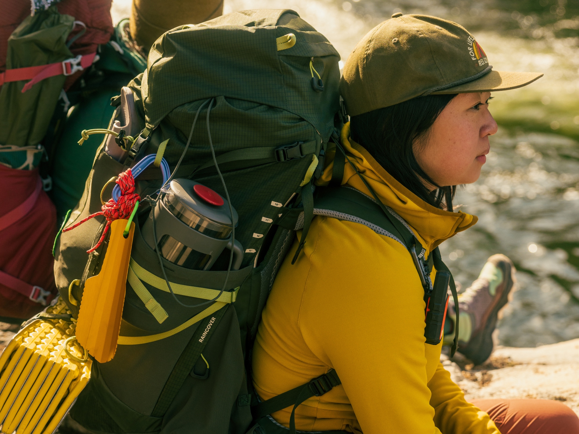 Two hikers stop to relax with their backpacks on.