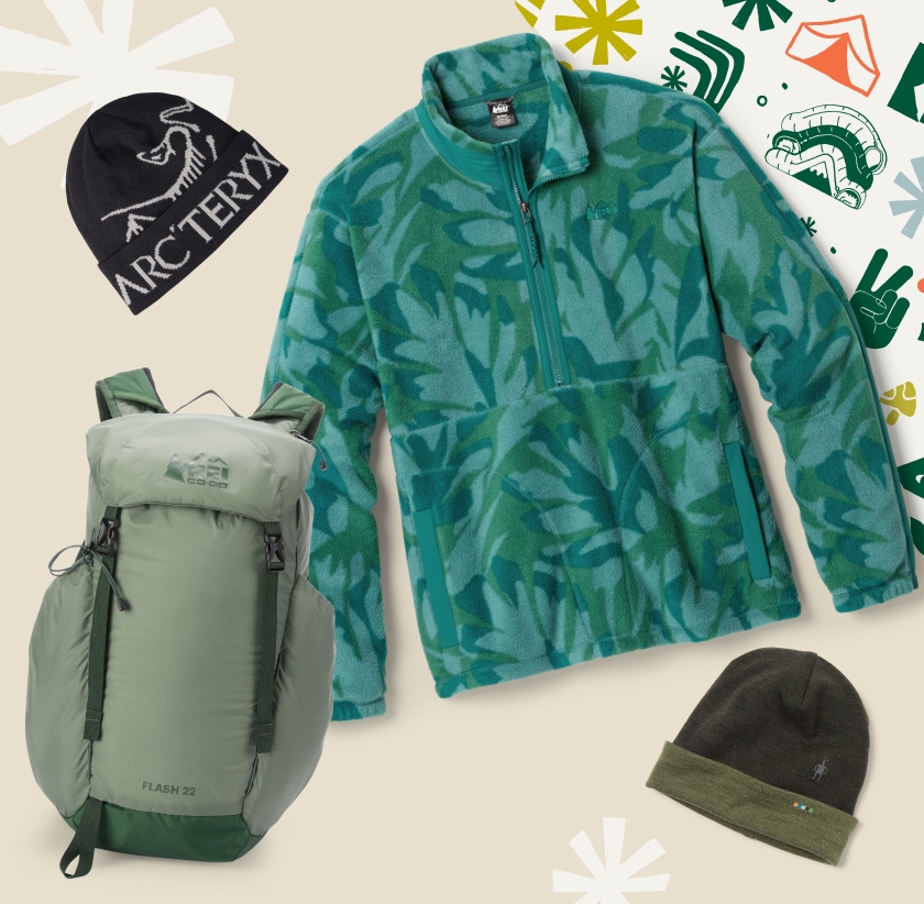 Wrapping paper with holiday motifs and a collage of beanies, a fleece jacket, and an R E I Co-op brand backpack.