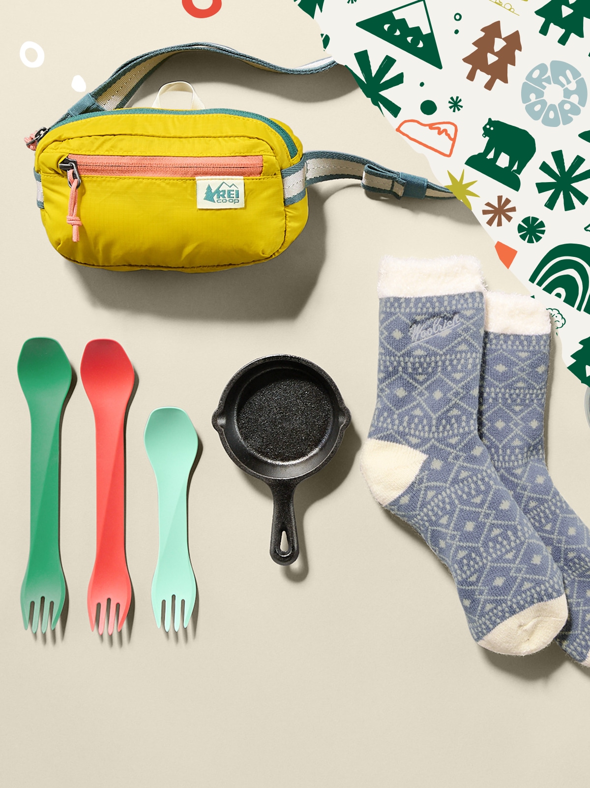 A collage of stocking stuffers on a light colored background with holiday wrapping paper in the corner.