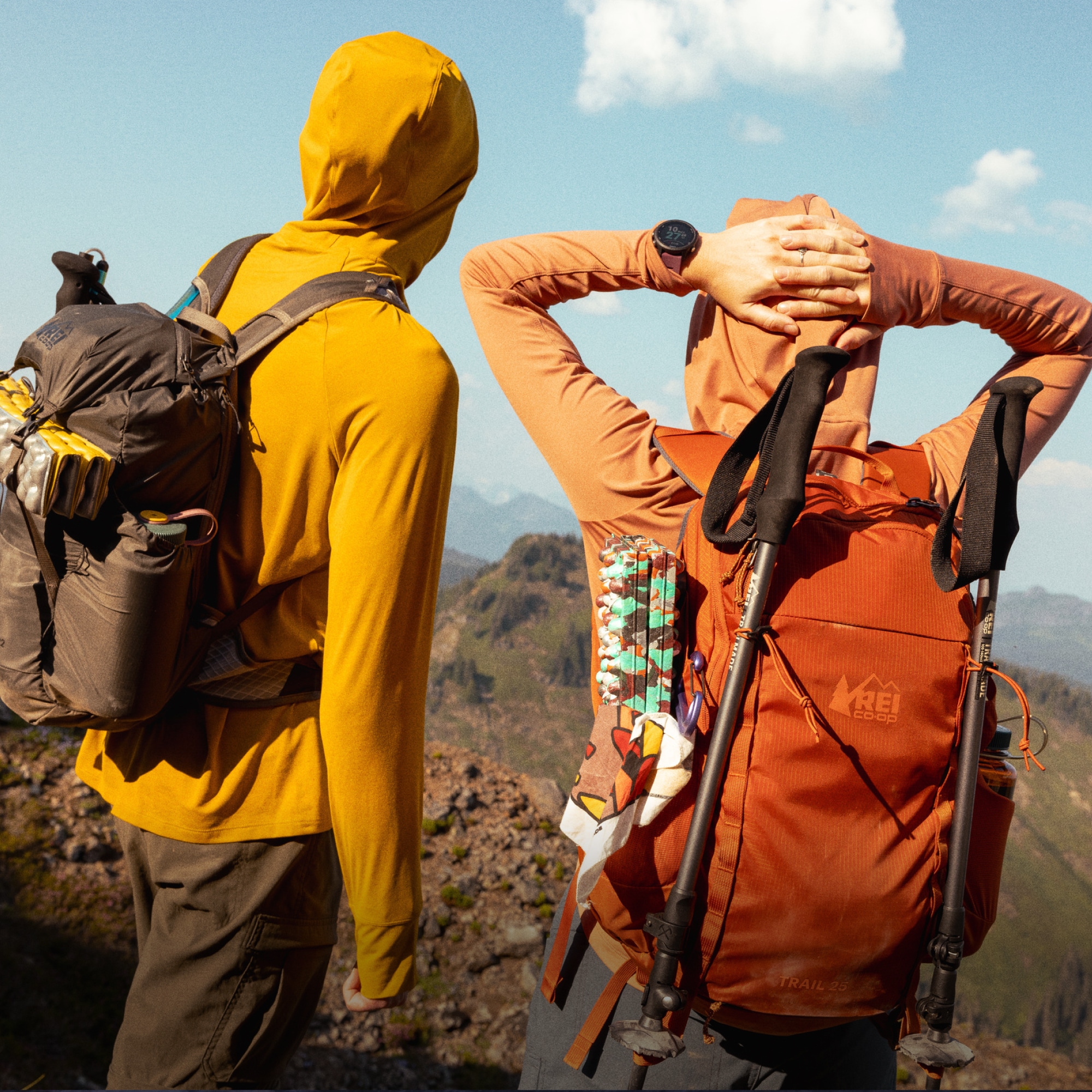 Two people take a break from hiking to admire the view from the top of a rock.