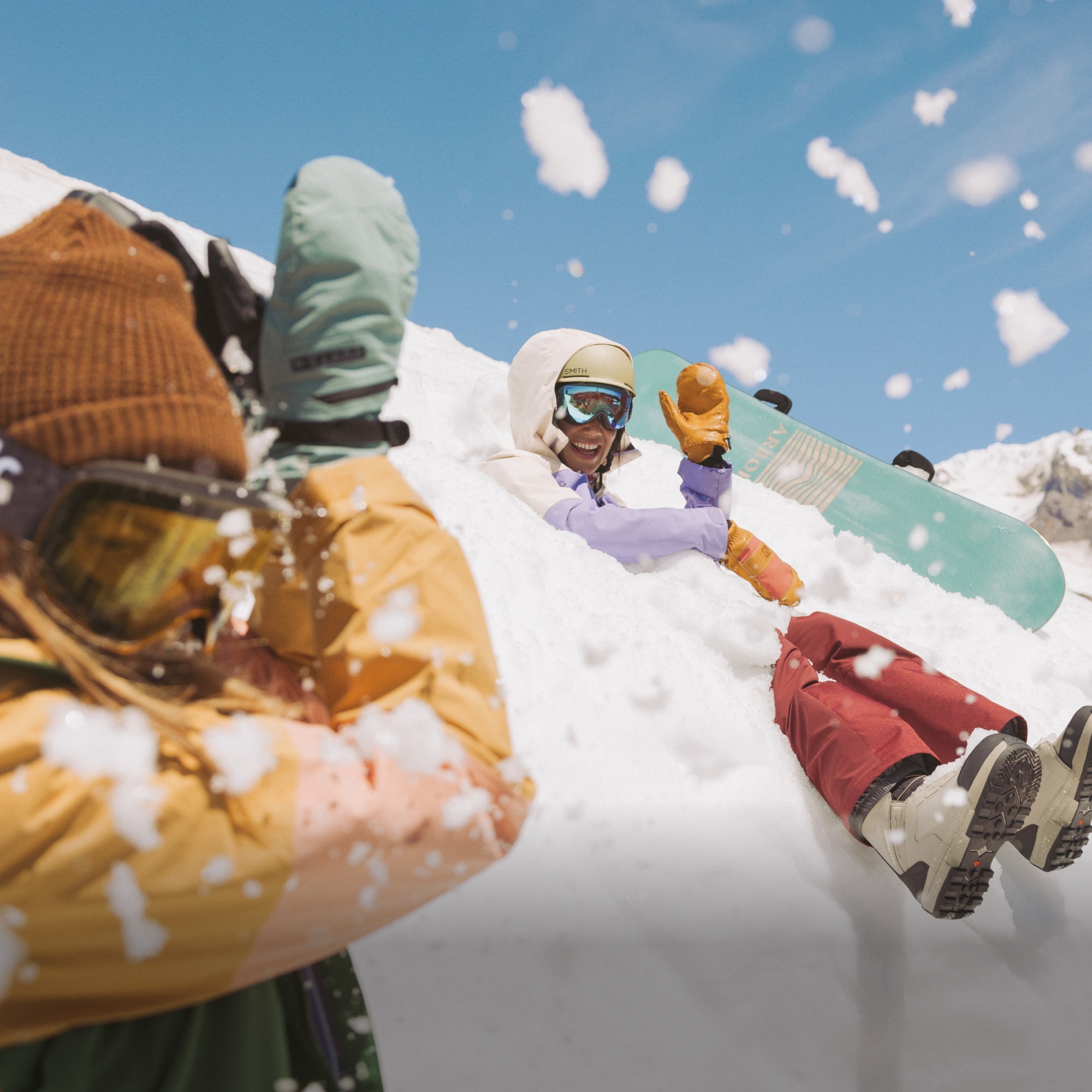 Two people laugh and play in the snow.