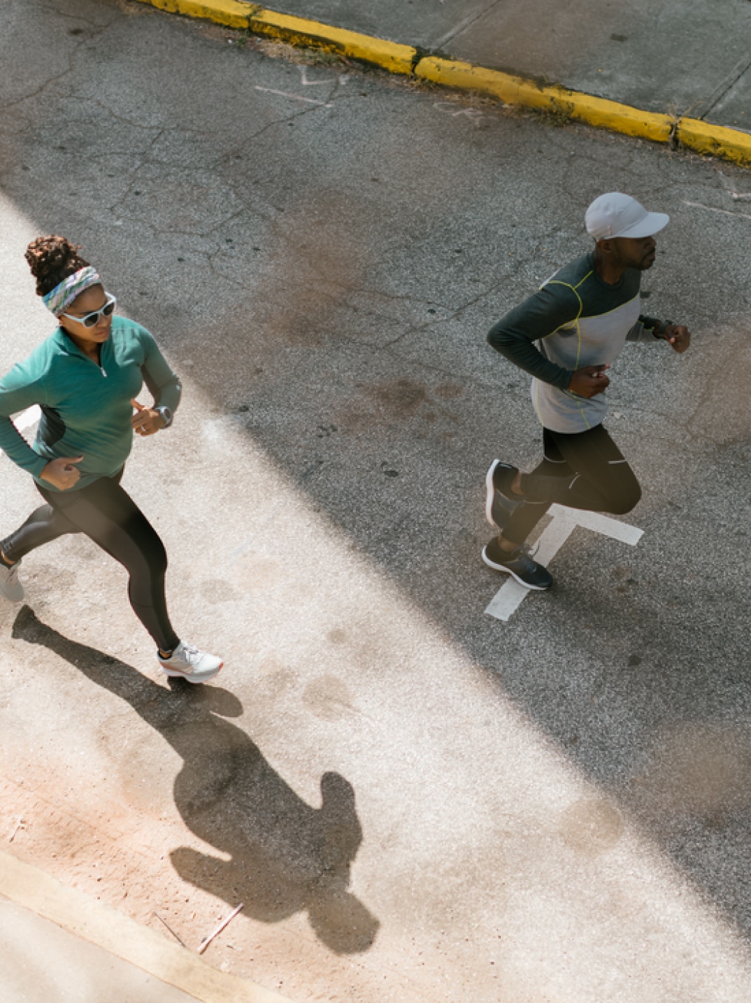 Two people run on a paved road.