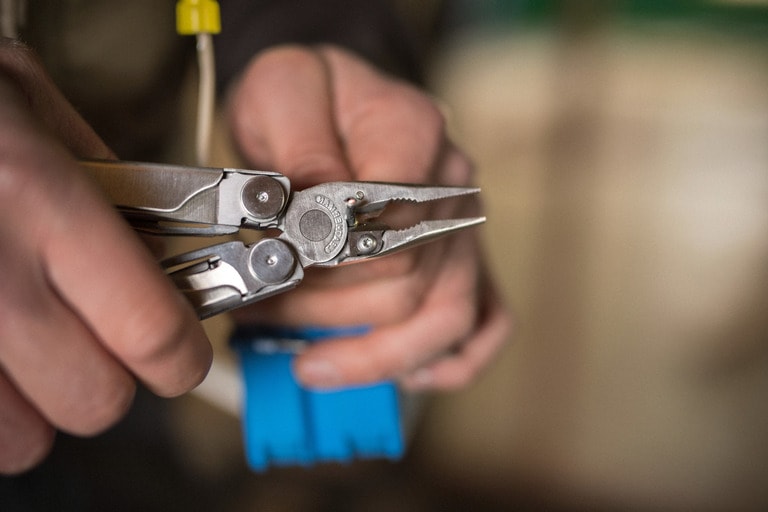 A close-up shot of someone cutting wire with a multi-tool