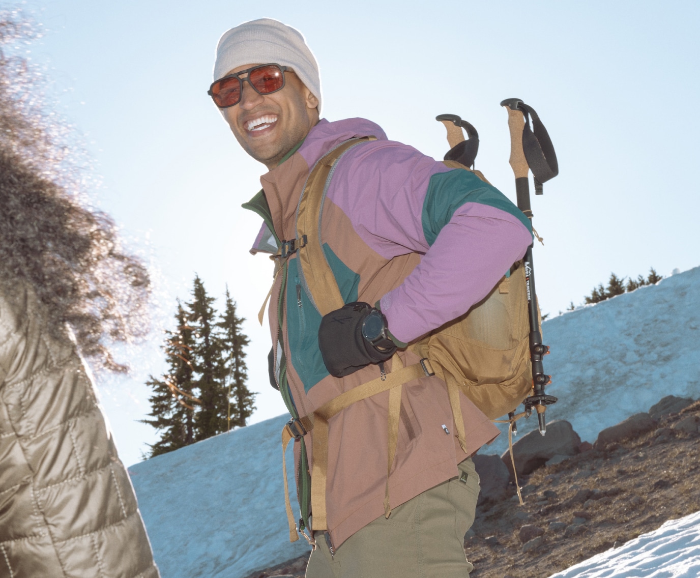 A person wearing winter clothing laughs and smiles for the camera.