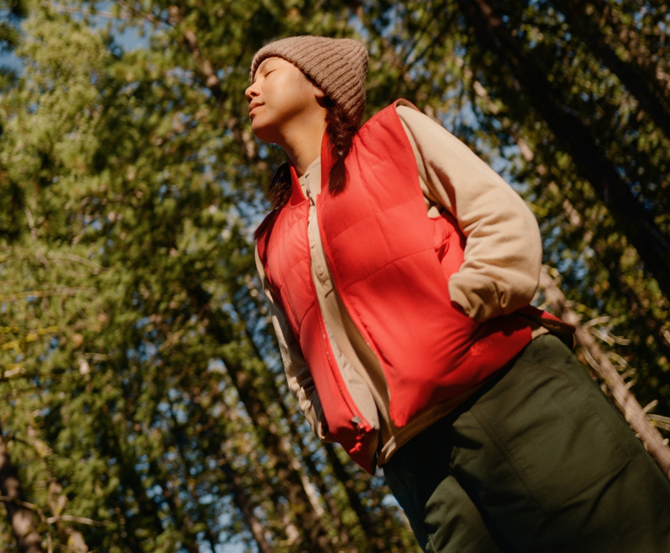 A person looks up into the sky with their eyes closed.