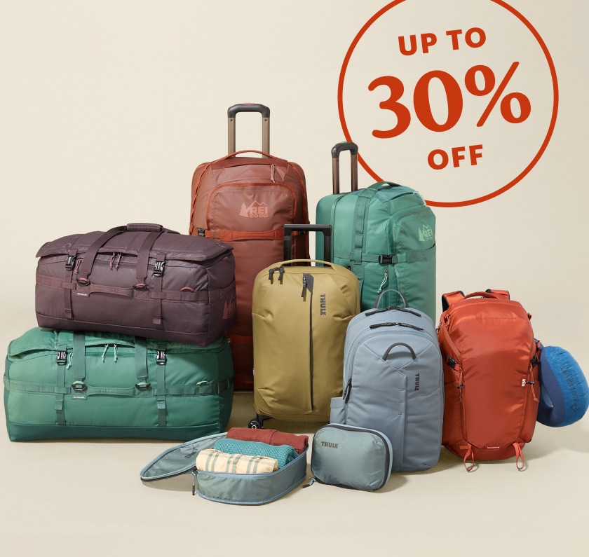 Up to 30% off. A collage of colorful travel bags on a light colored background.