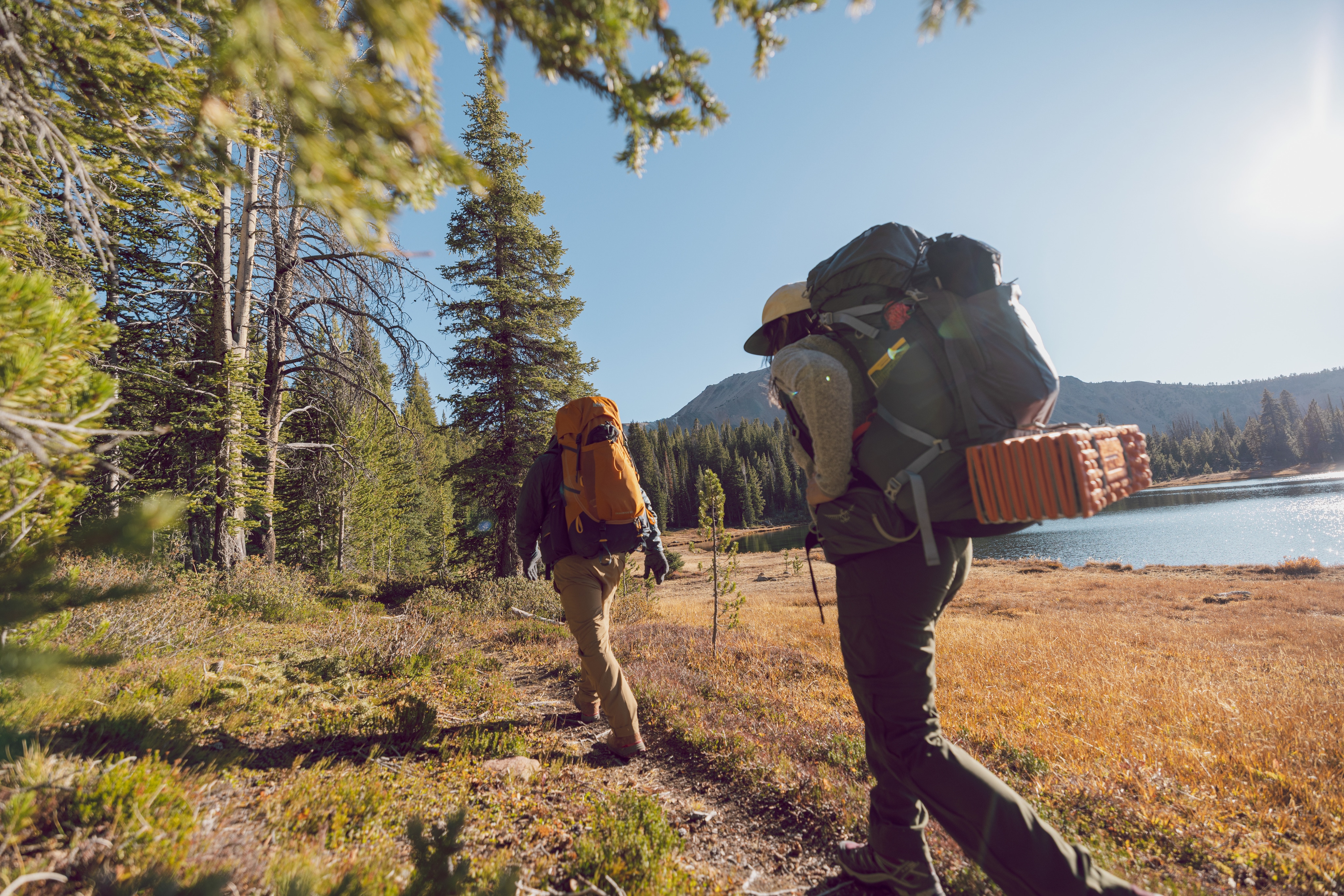 Two backpackers hike near a lake