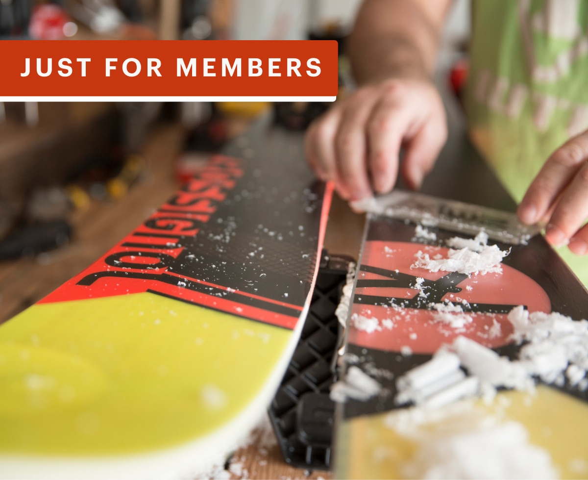 A person waxes a pair of skis.