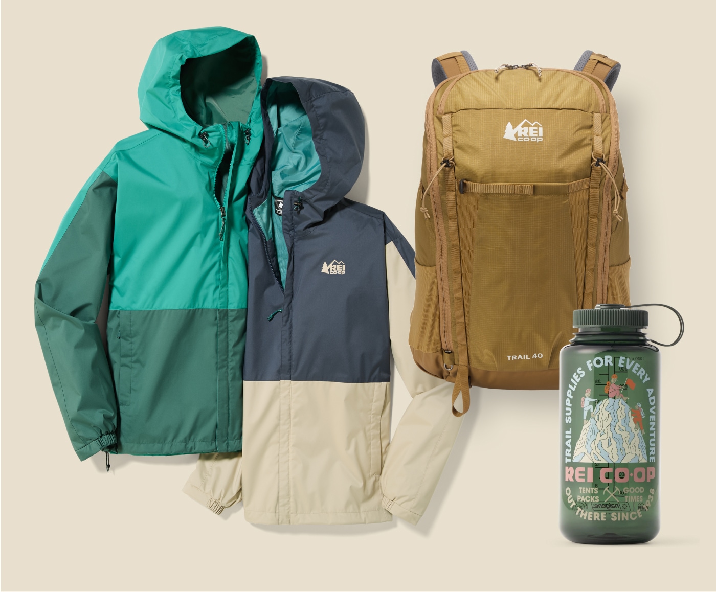 Two R E I Co-op brand jackets, a backpack, and a Nalgene water bottle on a light colored background.