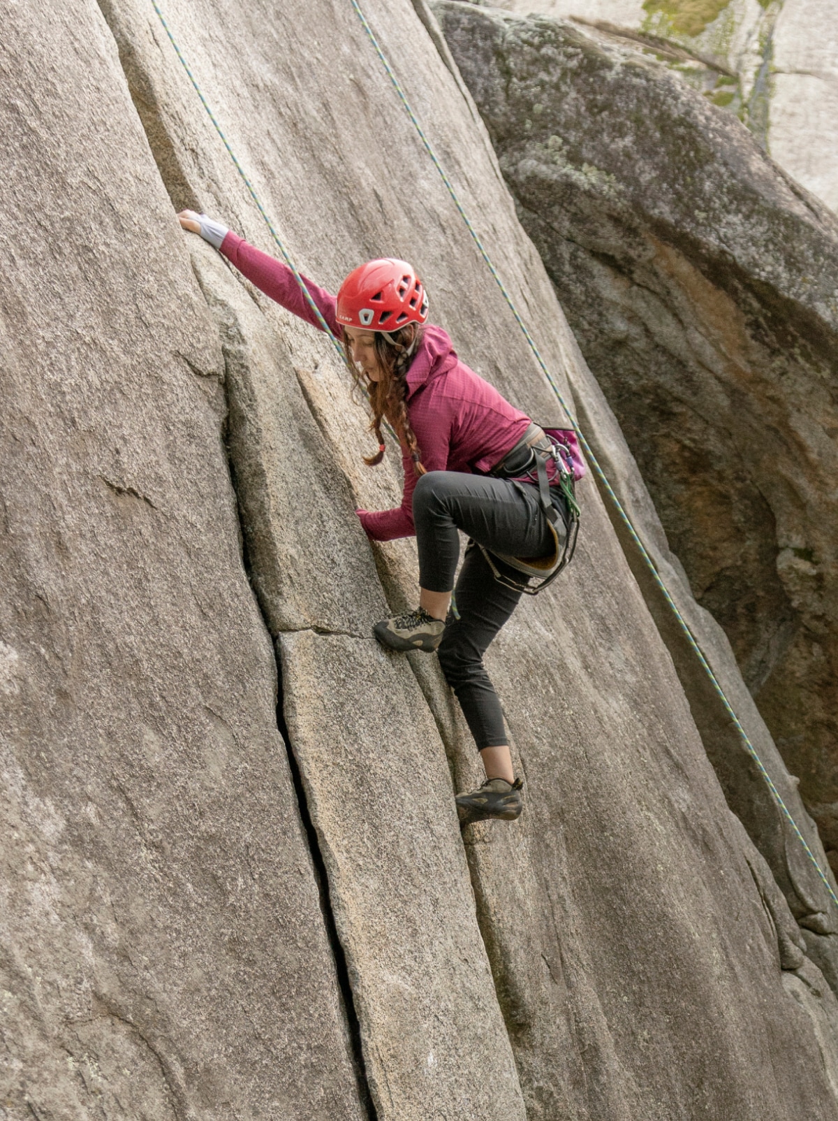 A person climbs up the side of a rock face.
