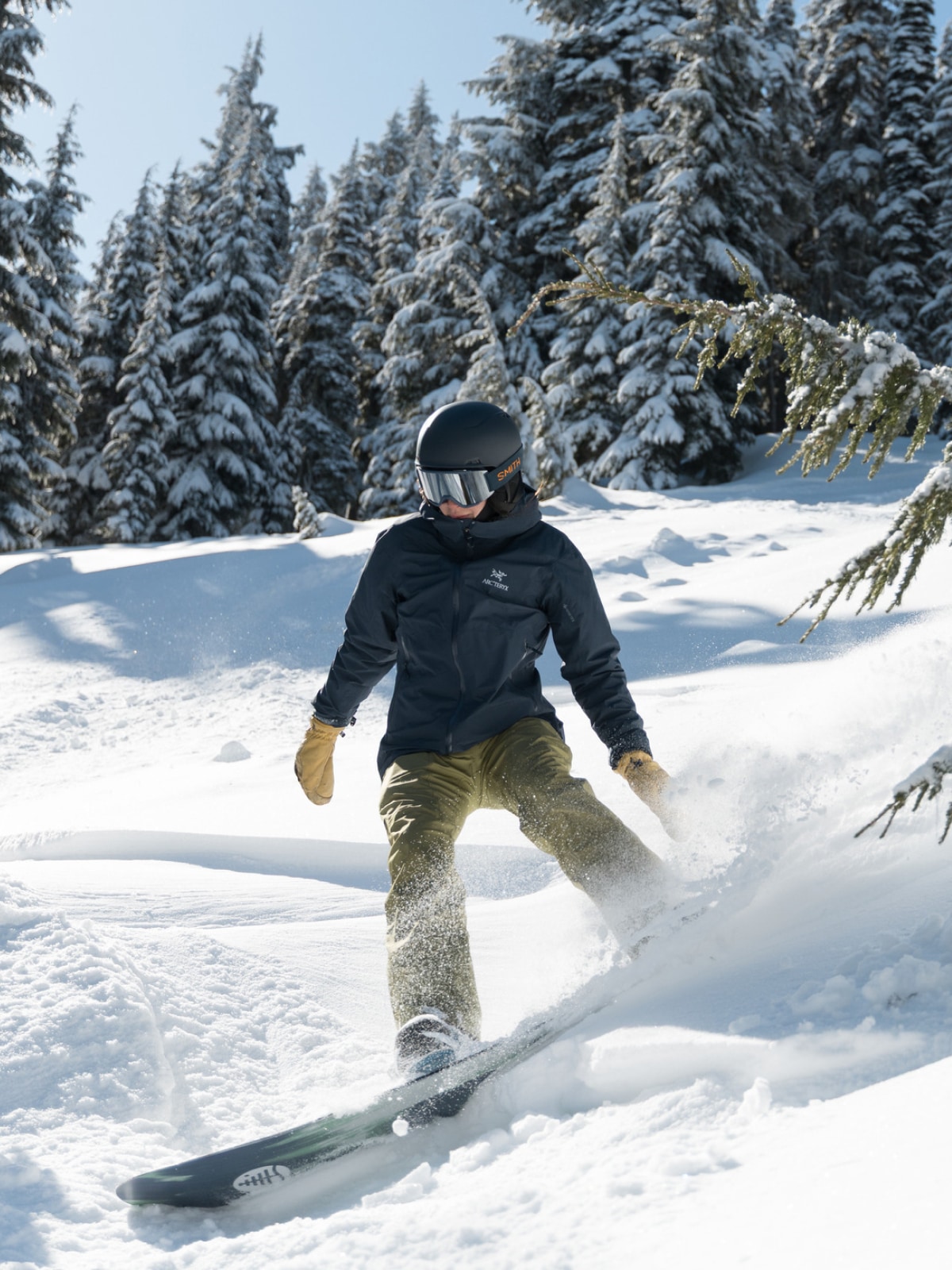 A person carves down a snowy mountain on their snowboard.