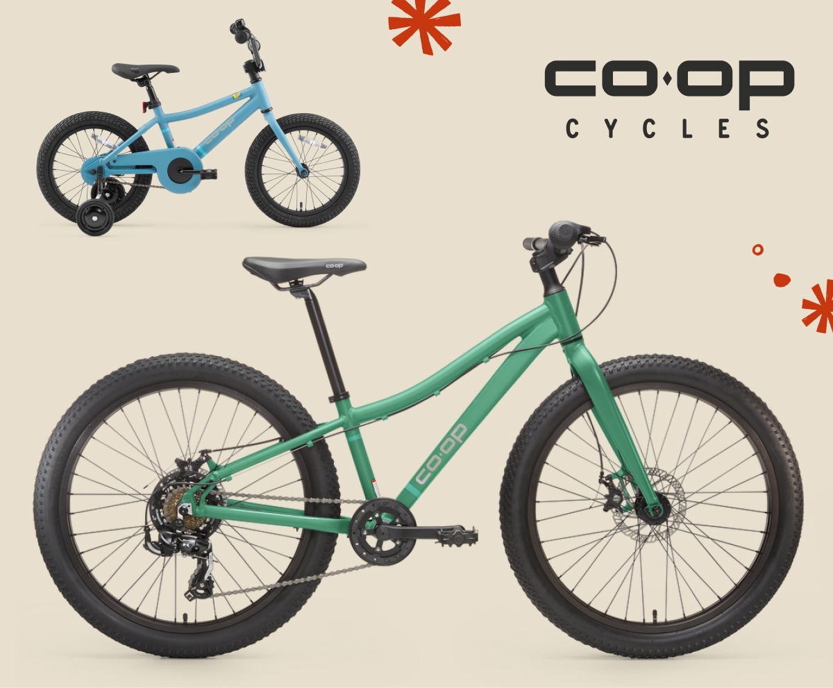 Two R E I Co-op Cycles bikes for kids on a light colored background.