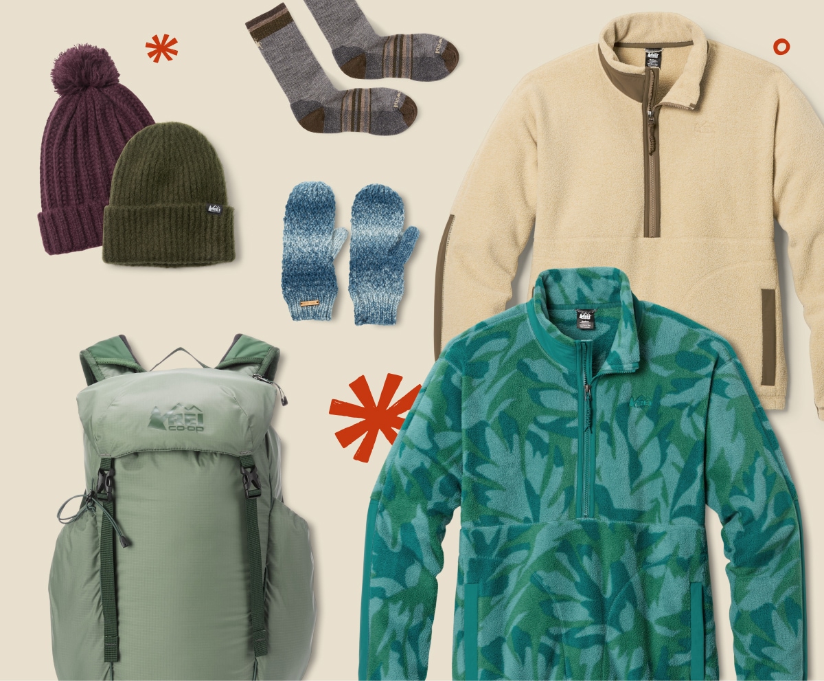 Hats, socks, gloves, a backpack, and two fleece jackets over a light colored background.