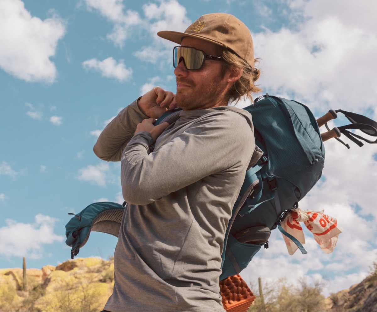 A person pulls on their pack.