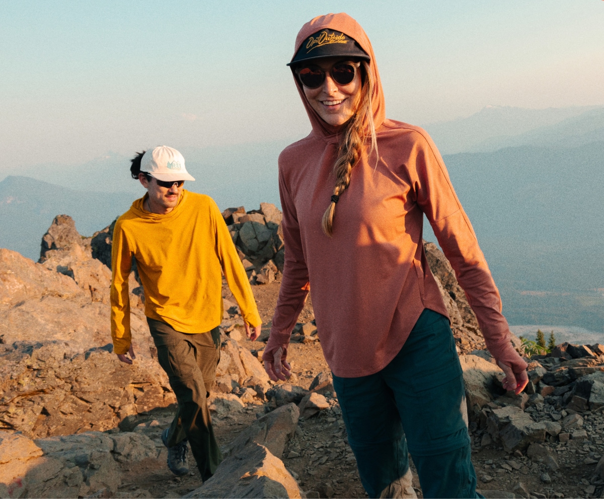 Three people laugh and smile while on a hike.