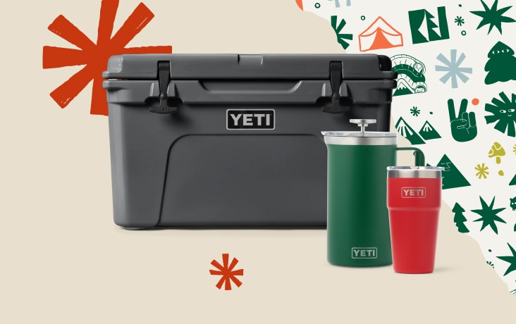 A cooler, french press, and stackable cup from YETI on a light colored background with snowflakes.