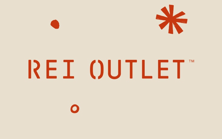 Text reads: ‘R E I Outlet’ on a light colored background with snowflakes.