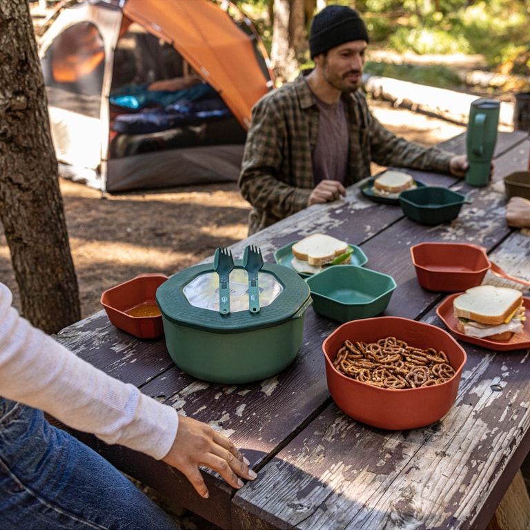 Picture of a set of servingware on a picnic table at camp
