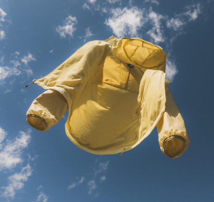 A yellow The North Face Ridgelite jacket floats in the sky.