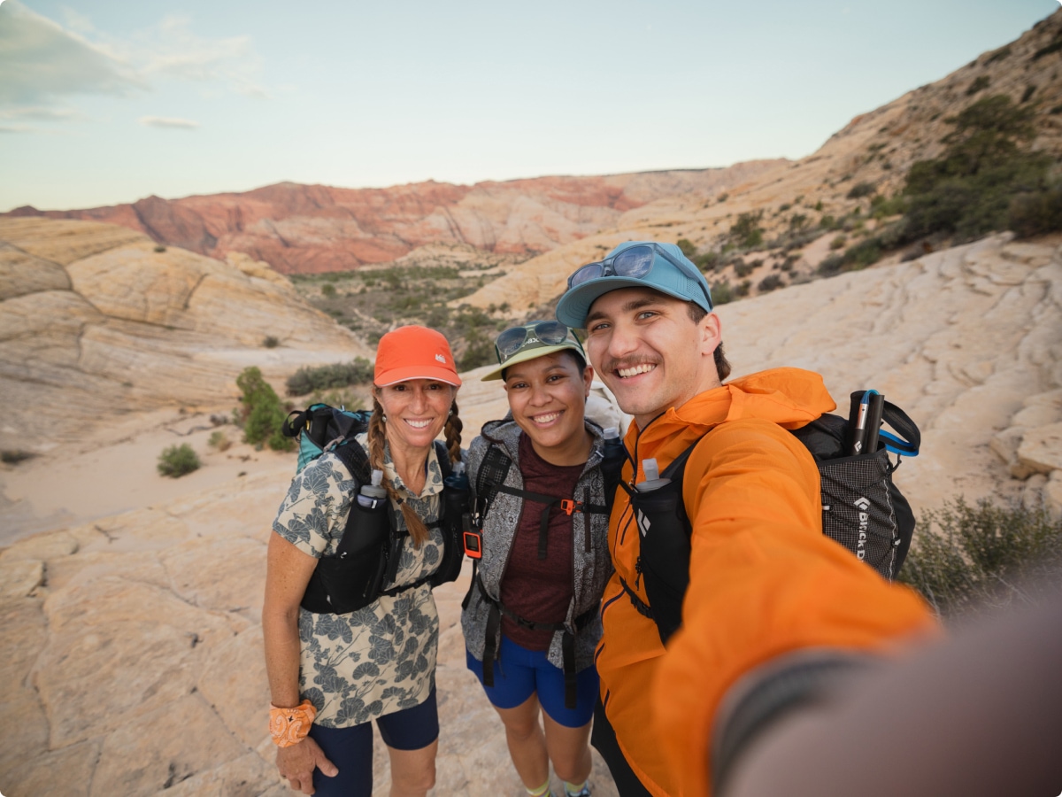 Three people stop during their hike to take a group photo.