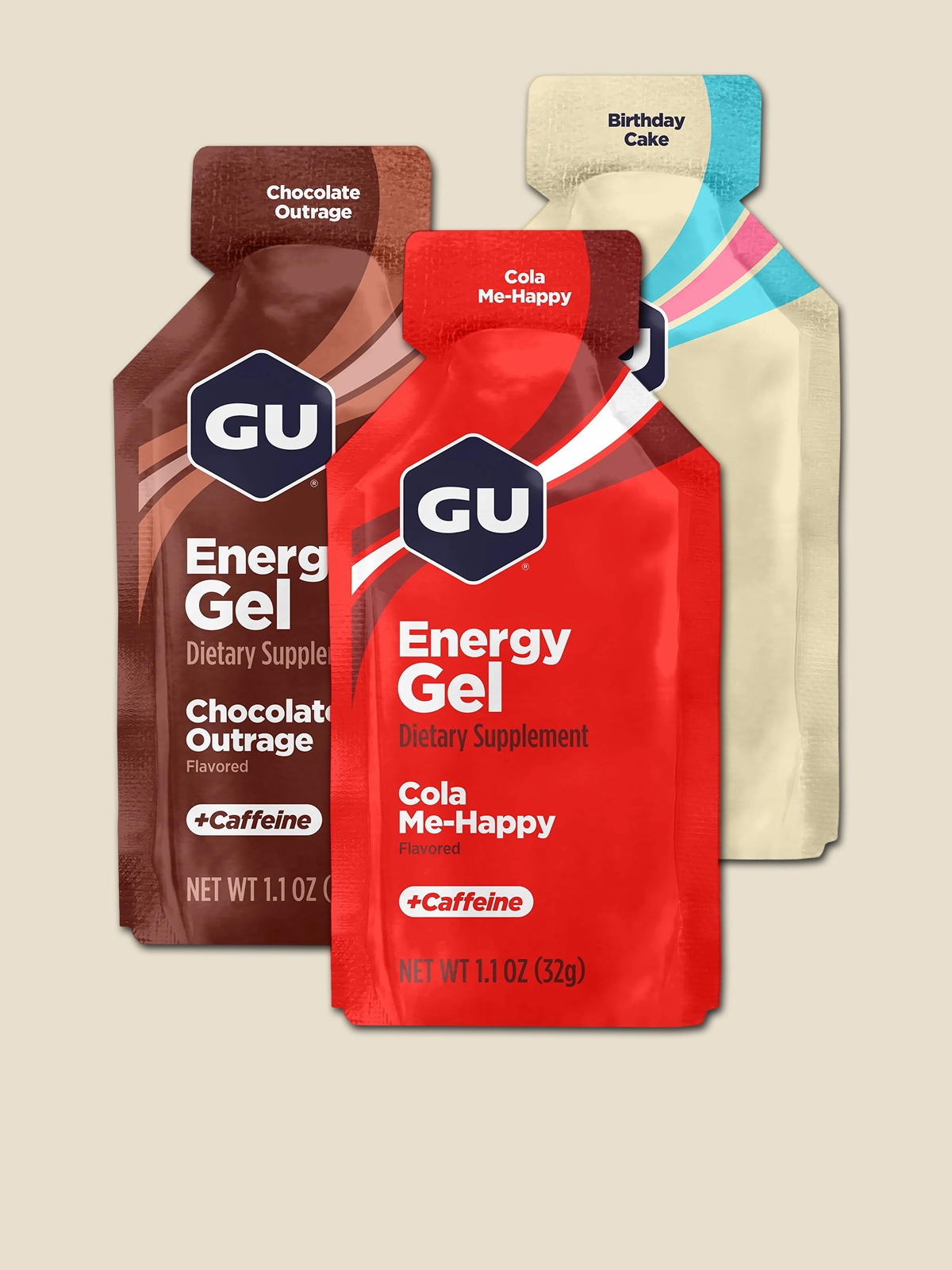 Three GU energy gel packets on a light colored background.