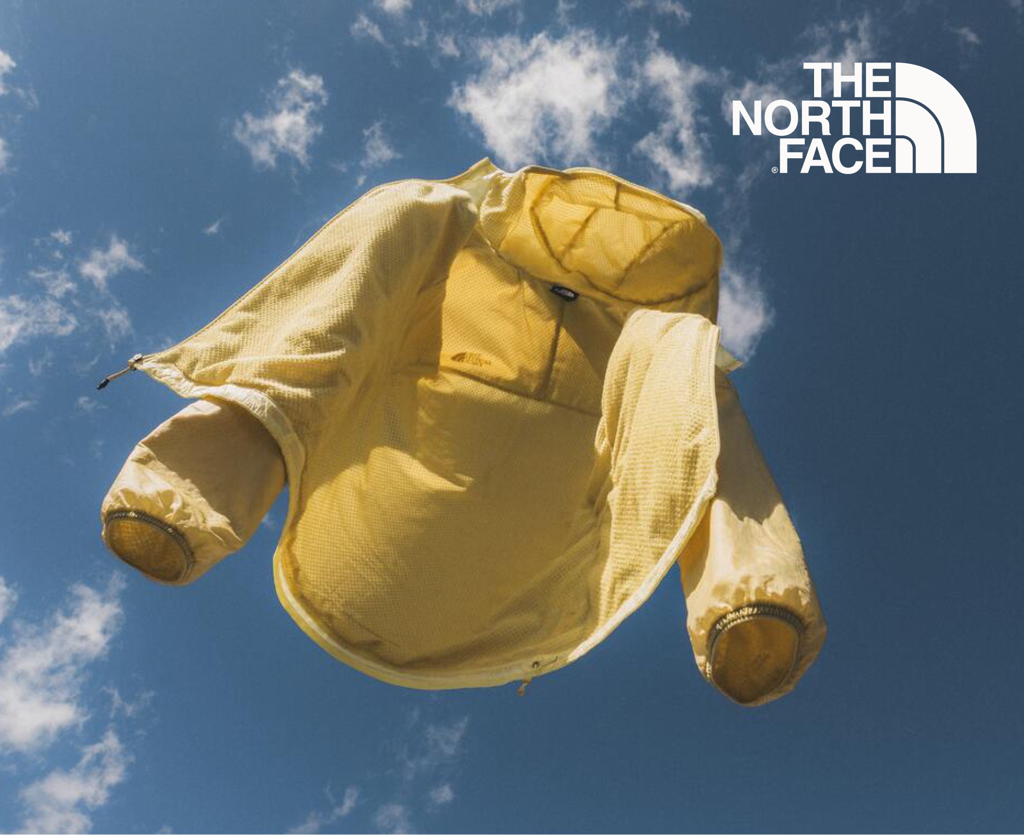 A yellow The North Face Ridgelite jacket floats off into the sky.