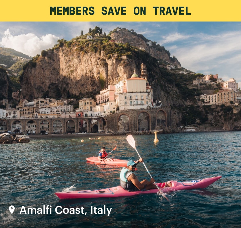 A yellow banner that reads: ‘Members save on travel’ over an image of people kayaking in the Amalfi Coast.