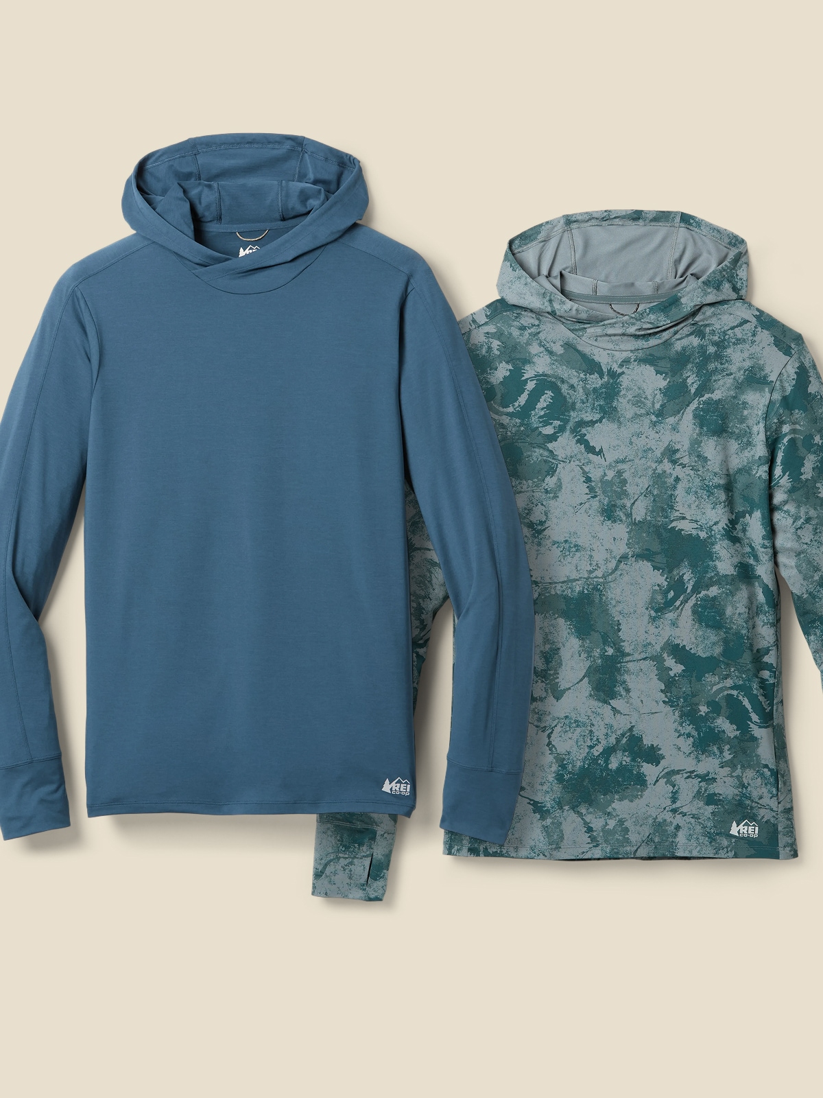 Two men’s long-sleeves from the R E I Co-op brand on a light colored background.
