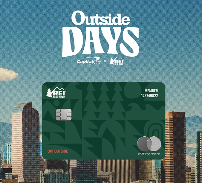 A green REI Co-op Mastercard credit card is displayed in front of a city skyline, with the text 'Outside Days' above.