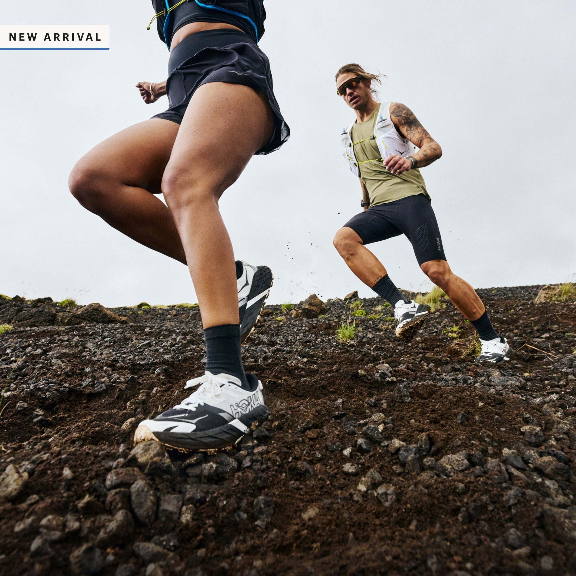 New arrival. Two people run through rocky terrain in their HOKA Speedgoat 7 shoe..s. 