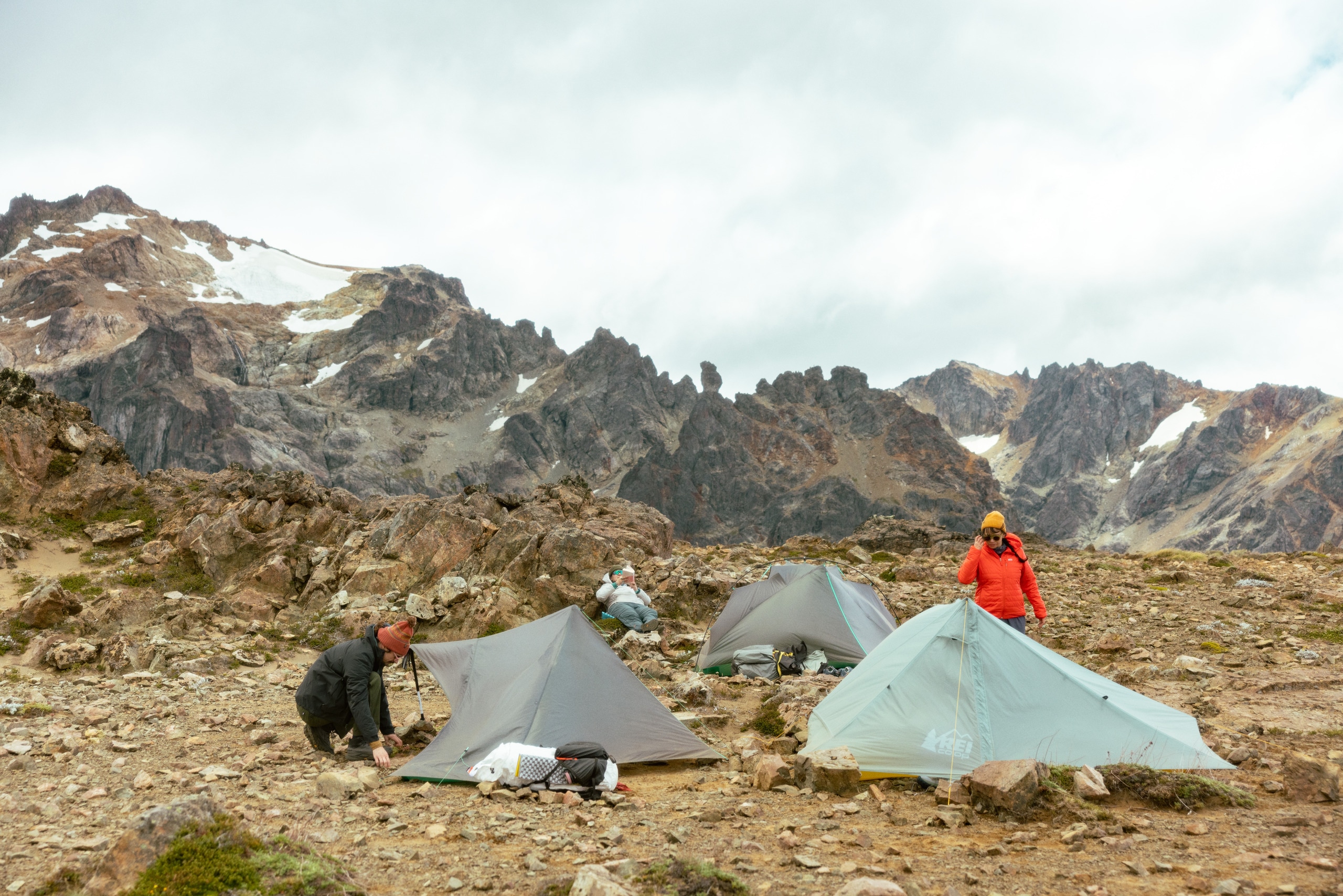 Photo of two people setting up tents in the backcountry.