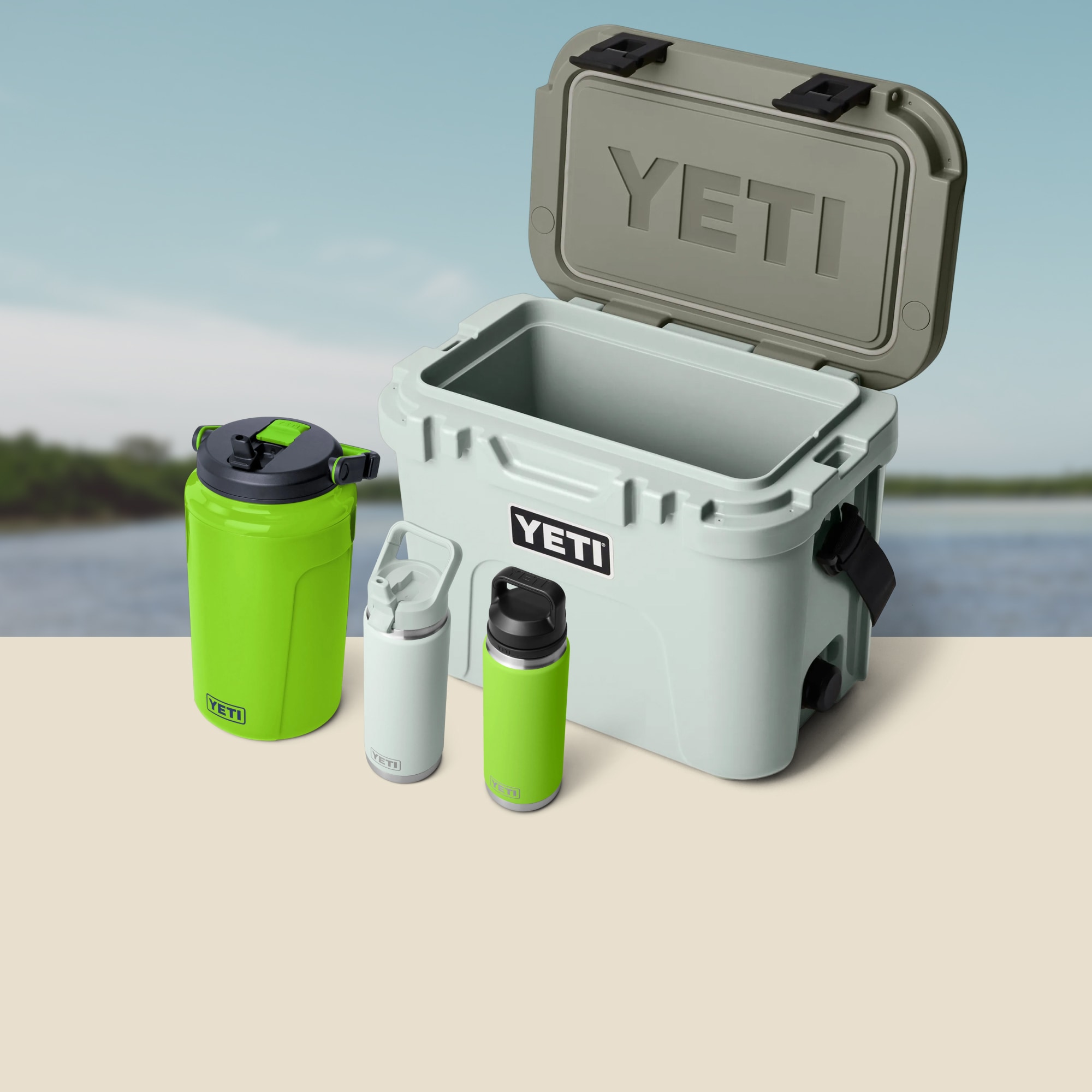A cooler and drinkware over an image of a lake.
