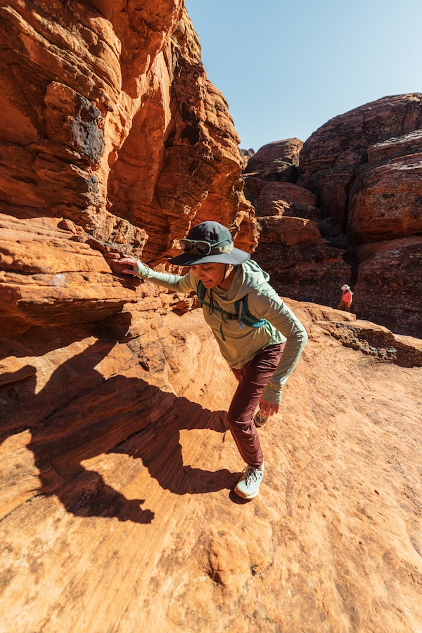 A person hiking up a desert canyon on a clear day.