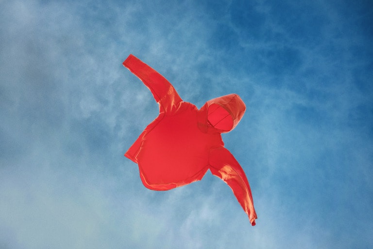 A red sun hoodie is floating in the sky