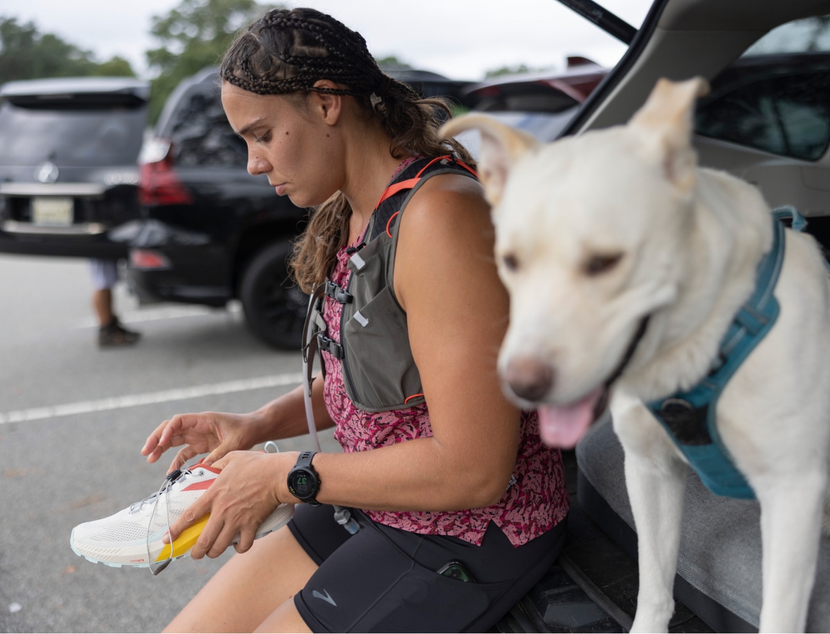 A runner and a dog prepare to hit the trail.